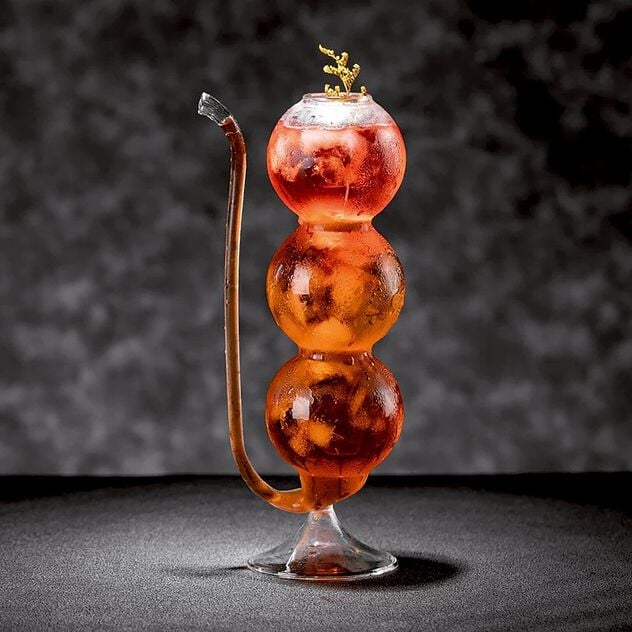 Cocktail glass with spherical shape and straw image number 1
